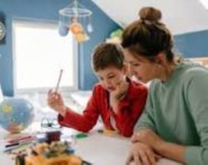 Mother and son studying together at home with open books on the table